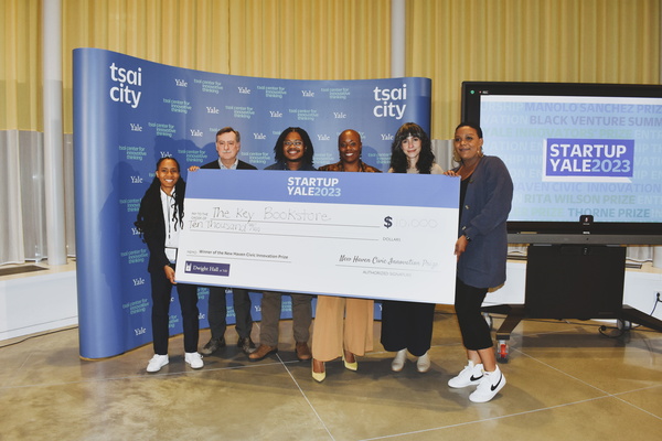 group of people holding a giant check